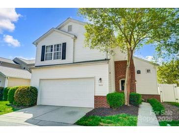 Charming two-story home features a white exterior, attached garage, and well-manicured landscaping at 9052 Meadowmont View Dr, Charlotte, NC 28269