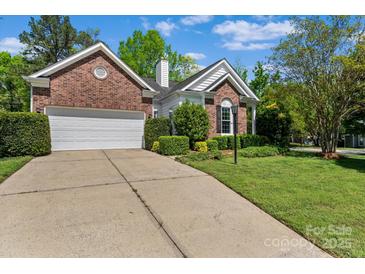 Charming brick home with a well-manicured lawn and a two-car garage with a concrete driveway at 11841 Mourning Dove Ln, Charlotte, NC 28269