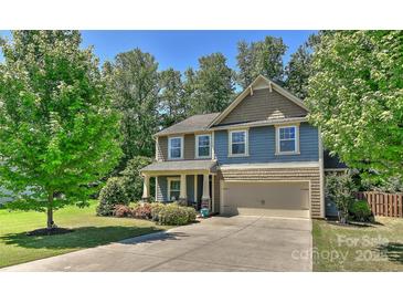 Charming two-story home with a manicured lawn, mature trees and a two-car garage at 15035 Ockeechobee Ct, Mint Hill, NC 28227