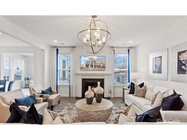 Bright living room with fireplace, modern light fixture, and neutral decor at 2212 Indigo Branch Rd, Indian Land, SC 29707