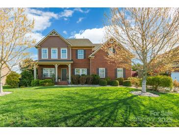 Charming two-story brick home with a manicured lawn and inviting front porch, showcasing curb appeal at 2610 Mchanna Pt, Fort Mill, SC 29708
