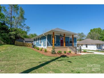 Charming blue home with a inviting front porch and beautifully landscaped front yard, perfect for curb appeal at 406 Williamson St, Fort Mill, SC 29715