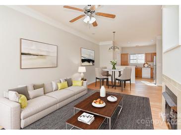 Bright living room featuring neutral tones, a dining area, and a glimpse into the well-lit, functional kitchen at 6512 Quarterbridge Ln, Charlotte, NC 28262