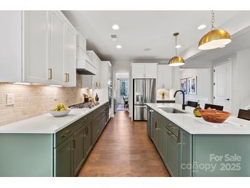 Bright, modern kitchen with stainless steel appliances, island, and stylish lighting fixtures at 6707 Baker Creek Ave, Indian Land, SC 29707