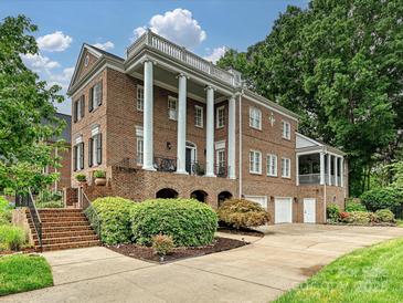 Stately brick home featuring a grand facade with large columns and well-manicured landscaping at 8623 Tullamore Park Cir, Charlotte, NC 28226