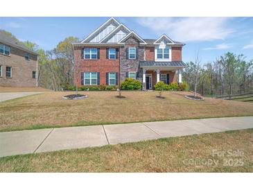 Beautiful two-story brick home with a manicured front yard and inviting entrance at 9032 Cornflower Dr, Harrisburg, NC 28075