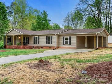 Charming single-story home with a brick foundation, vinyl siding, a covered front porch and car port at 141 Hickory Creek Dr, Gastonia, NC 28052