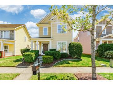 Charming two-story home with a well-manicured lawn, lush landscaping, and inviting front porch at 16431 Leavitt Ln, Davidson, NC 28036