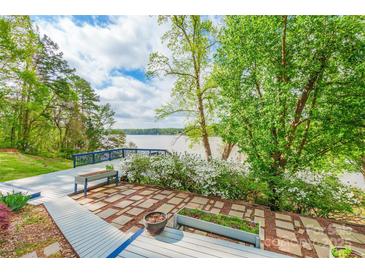 Inviting lakefront deck and stone patio provides a serene outdoor living space with beautiful water views at 1720 Gaither Rd, Belmont, NC 28012