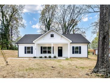 Charming white cottage-style home featuring black shutters, a covered porch, and a well-maintained front yard at 315 Club House Dr, Salisbury, NC 28144