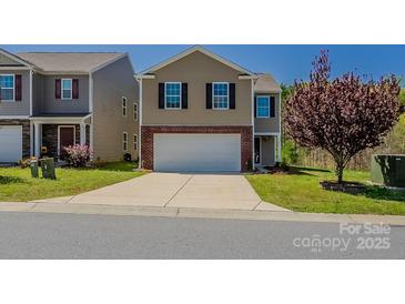 Traditional two-story home with a brick-accented front, two-car garage, and a well-maintained front lawn at 4200 Long Arrow Dr, Concord, NC 28025