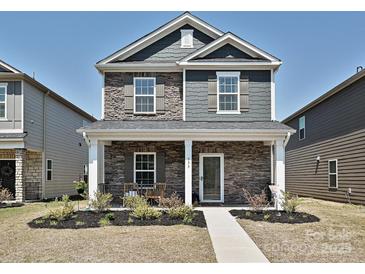 Charming two-story home with stone accents, covered front porch and beautiful landscaping at 533 Cedar Knoll Cir, Pineville, NC 28134