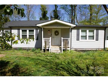 Charming single story home featuring a welcoming front porch, black shutters, and a well-maintained lawn at 6124 Old Plank Rd, Charlotte, NC 28216