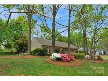 Charming one-story home with brick facade and lush front yard landscaping at 8605 Ducksbill Dr, Charlotte, NC 28277