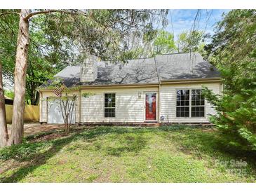 Inviting one-story home with a manicured lawn and an attached garage, set beneath mature trees at 10432 Camelback Cir, Charlotte, NC 28226