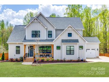 Charming two-story home features a welcoming front porch, well-manicured lawn, and a two-car garage at 1079 Sage Pine Cir, Clover, SC 29710