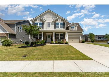 Charming two-story home featuring a welcoming front porch and a well-manicured lawn, perfect for curb appeal at 11234 Smokethorn Nw Dr, Concord, NC 28027