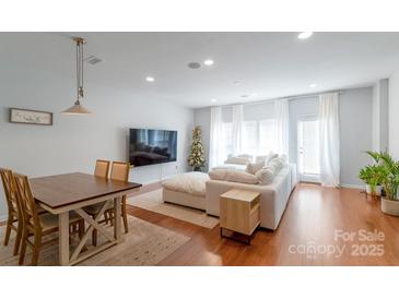 Bright living room features a dining area and a plush sectional couch by a large window at 12036 Duke Lancaster Dr, Charlotte, NC 28277