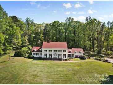 Expansive home featuring a classic facade with white columns, a red roof, and a sprawling green lawn at 1233 General Hoke Dr, Lincolnton, NC 28092