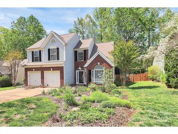 Charming two-story home with a well-manicured lawn, flower beds, and an attached two-car garage at 1432 Deer Forest Dr, Fort Mill, SC 29707