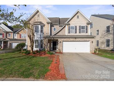 Charming two-story home featuring brick and siding exterior, a two-car garage, and a well-manicured front yard at 15814 Herring Gull Way, Charlotte, NC 28278