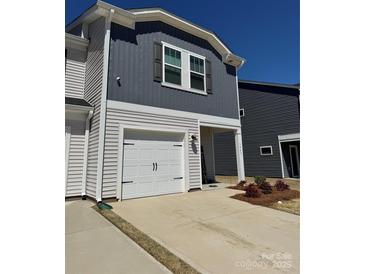 Charming home featuring gray and white siding, a single-car garage, and a welcoming entryway at 1843 Old Rivers Rd # 209, Concord, NC 28027