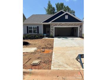Charming single-story home featuring stone accents, an attached two-car garage, and a well-maintained lawn at 5711 Skinny Down, Charlotte, NC 28215