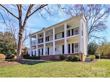 Stately two-story home with a columned front porch and second-story balcony, offering classic Southern charm at 8600 Peyton Randolph Dr, Charlotte, NC 28277