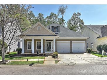 Charming home features a two-car garage, well-manicured lawn, and a cozy covered front porch with classic white columns at 9189 Glenashley Dr, Cornelius, NC 28031