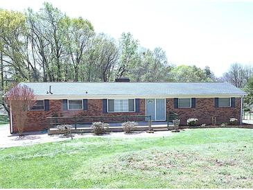 Charming single-story brick home with a well-maintained front yard, featuring a blend of mature trees at 9716 Sunway Dr, Mint Hill, NC 28227