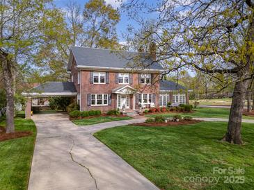 Elegant brick home with a circular driveway, manicured lawn, and a convenient carport at 10 North Rd, Salisbury, NC 28144