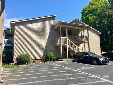 Inviting condo exterior with stairs to entrance, car parking, and attractive landscaping at 140 Lake Concord Ne Rd # D-1, Concord, NC 28025
