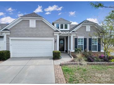 Charming home featuring a two-car garage, manicured landscaping, and a welcoming front porch entrance at 20202 Dovekie Ln, Indian Land, SC 29707