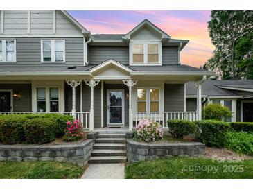 Charming home featuring a welcoming front porch with decorative columns and beautiful landscaping at sunset at 2756 Von Thuringer Ct, Charlotte, NC 28210