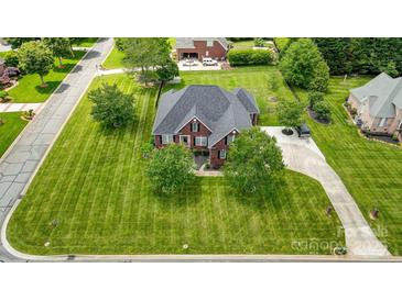 Expansive brick home with lush green lawn and mature trees on a well manicured lot from an aerial perspective at 3011 Patrick Place Cir, Clover, SC 29710