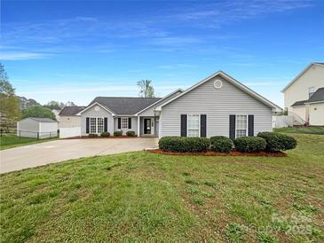 Charming single-story home featuring well-maintained landscaping and inviting curb appeal with grey siding at 4147 Timberwood Dr, Gastonia, NC 28056