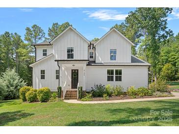 Charming two-story home with a manicured lawn, lush landscaping, and a welcoming front porch at 4195 Island Fox Ln, Denver, NC 28037