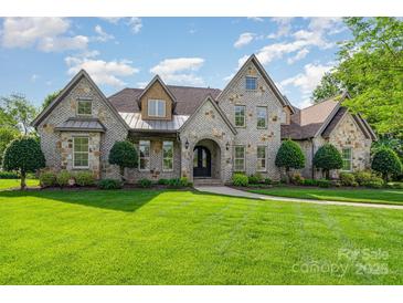 Stunning stone home with meticulously manicured lawn and mature landscaping creating a grand and welcoming curb appeal at 4904 Ardenetti Ct, Mint Hill, NC 28227