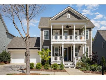 Charming two-story home featuring a double porch, well-manicured landscaping, and a two-car garage at 107 Iris Meadow Dr, Mooresville, NC 28115