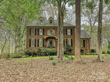 Traditional brick home with dark shutters, dormers, and mature landscaping at 2313 Beechwood Dr, Waxhaw, NC 28173