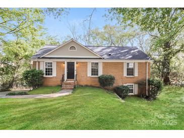 Charming brick home featuring a well-manicured lawn and traditional architectural details at 6001 Plaza Ln, Charlotte, NC 28215