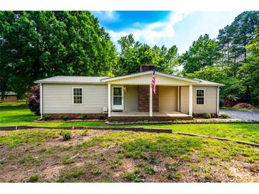Charming single-story home with brick accents, a well-maintained lawn and an American flag at 7050 Forney Hill Rd, Denver, NC 28037
