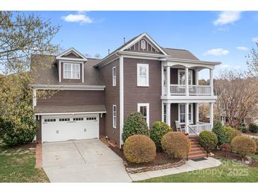 Charming two-story home with a two car garage, manicured landscaping, and inviting double-decker porch at 11204 Arlen Park Dr, Huntersville, NC 28078