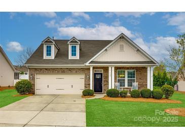Charming brick home with a two-car garage, dormer windows, a well-manicured lawn, and rocking chairs on the front porch at 1129 Black Walnut Rd, Clover, SC 29710