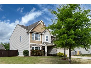 Two-story home with a two-car garage, complemented by a lush green lawn at 15225 Kissimmee Ln, Mint Hill, NC 28227