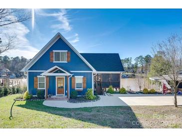 Charming blue home with a well-manicured lawn and a view of the lake at 428 Pinehaven Dr, New London, NC 28127