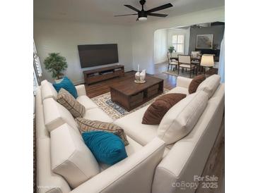 Bright living room featuring a large sectional sofa and stylish decor with an adjacent dining area at 6372 Morehead St, Harrisburg, NC 28075