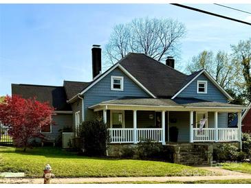 Charming two-story home featuring a welcoming front porch with white railing and well-maintained landscaping at 705 3Rd Nw Ave, Hickory, NC 28601