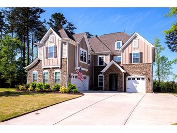 Attractive two-story home with a stone and siding exterior, showcasing a well-manicured lawn and a spacious driveway at 9878 Verdun Ct, Fort Mill, SC 29707