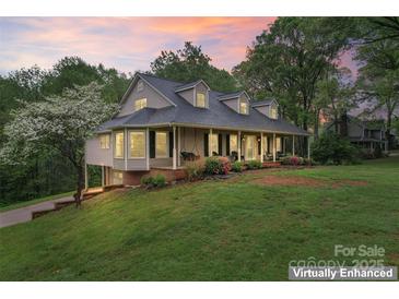 Beautiful home with a lush lawn, mature trees, and an inviting front porch with swings at 109 Windmill Rd, Salisbury, NC 28147